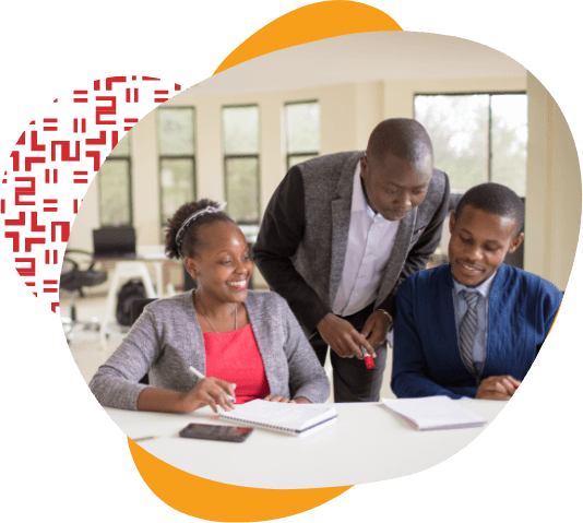 Mentor looking over two students shoulder to check their work